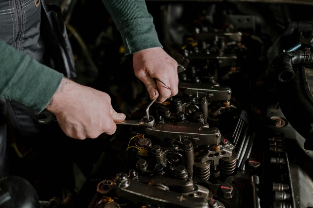 pexels photo 7564871 7564871 Close-up of a mechanic using hand tools to fix an engine, showcasing precision and skill.